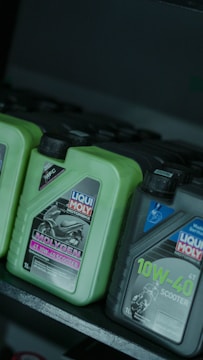 Motorcycle oil bottles on a shelf.