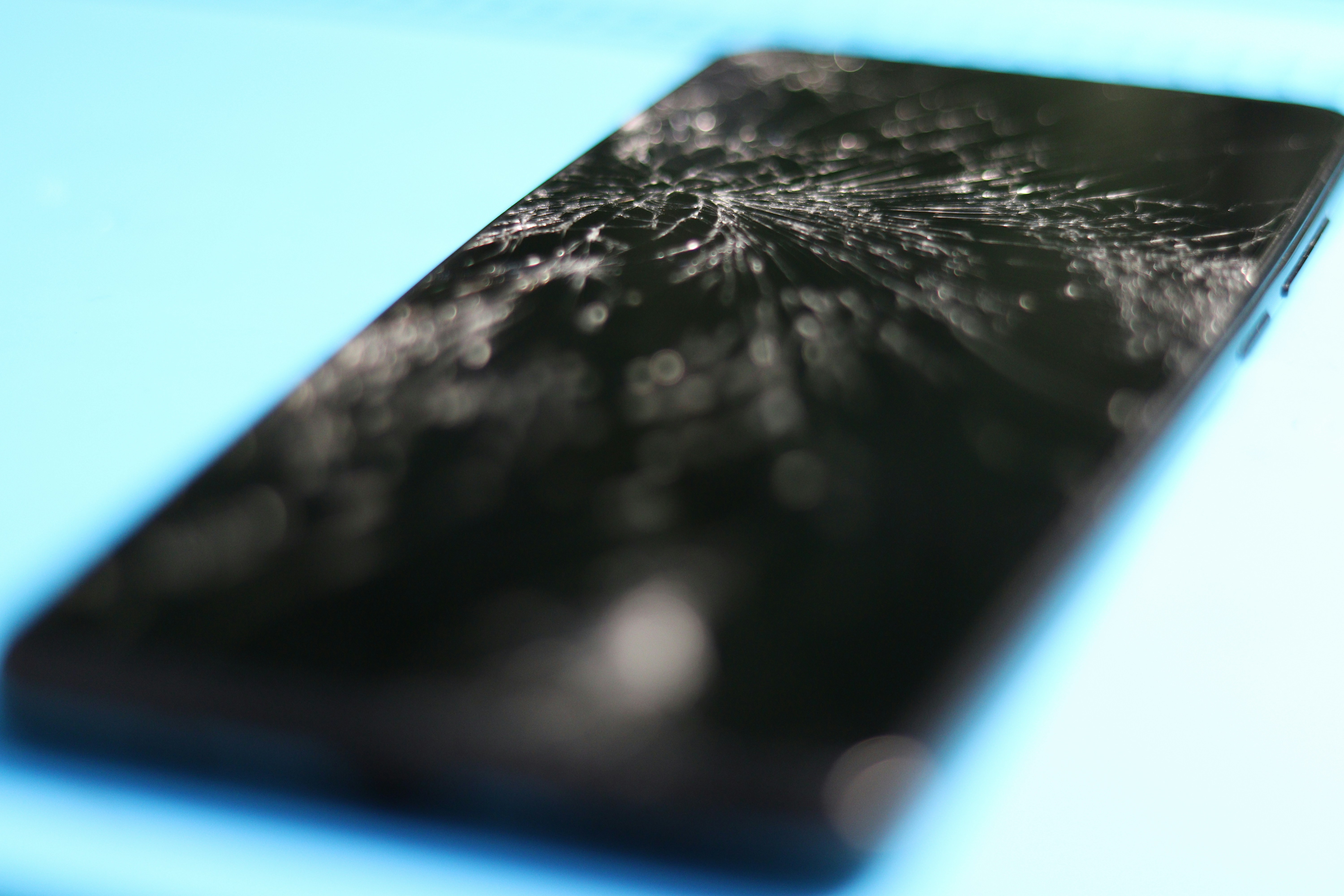 a smartphone with a badly cracked screen on a wooden table - young adult gadget cover