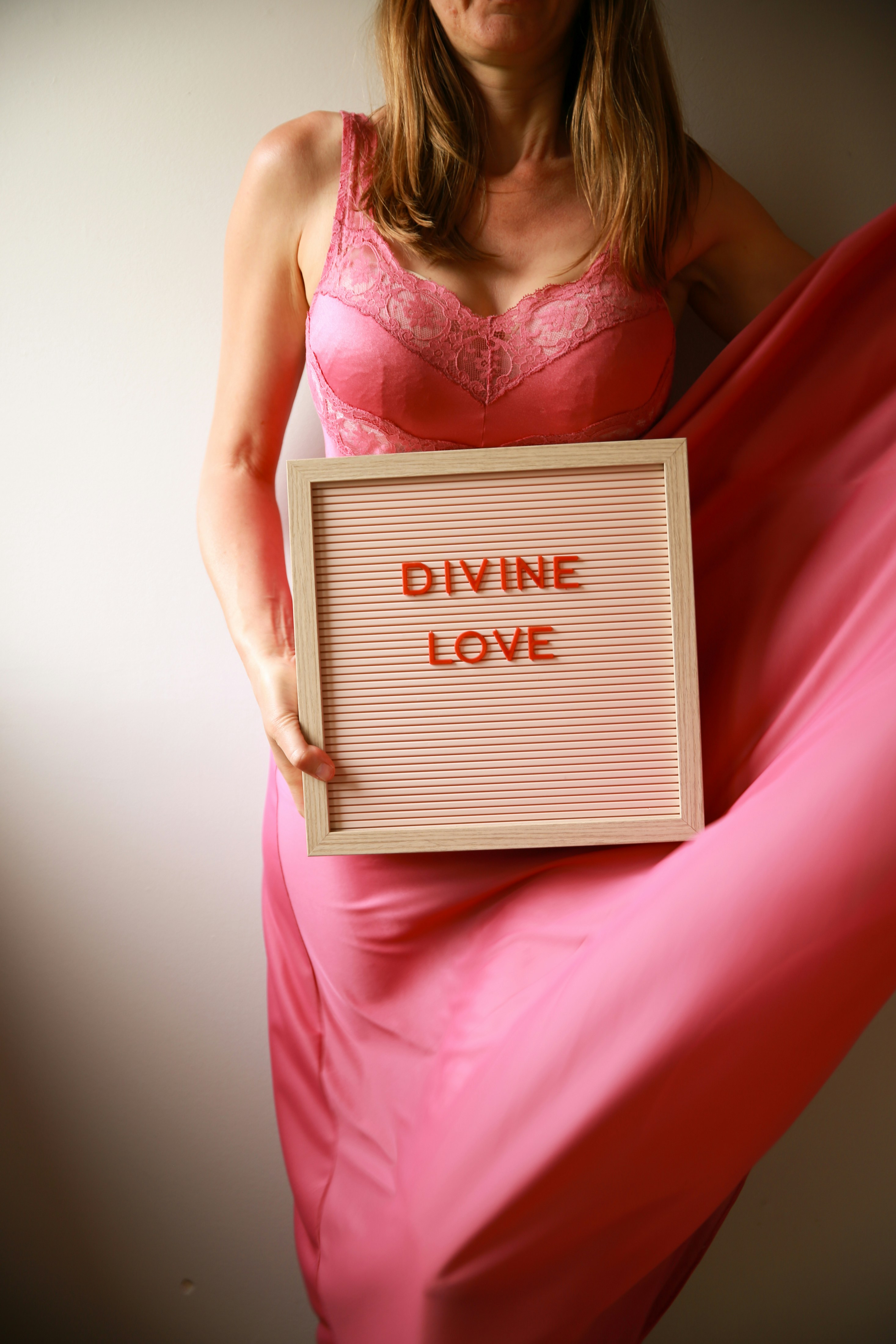 Die Frau hält ein Schild mit der Aufschrift "Göttliche Liebe".