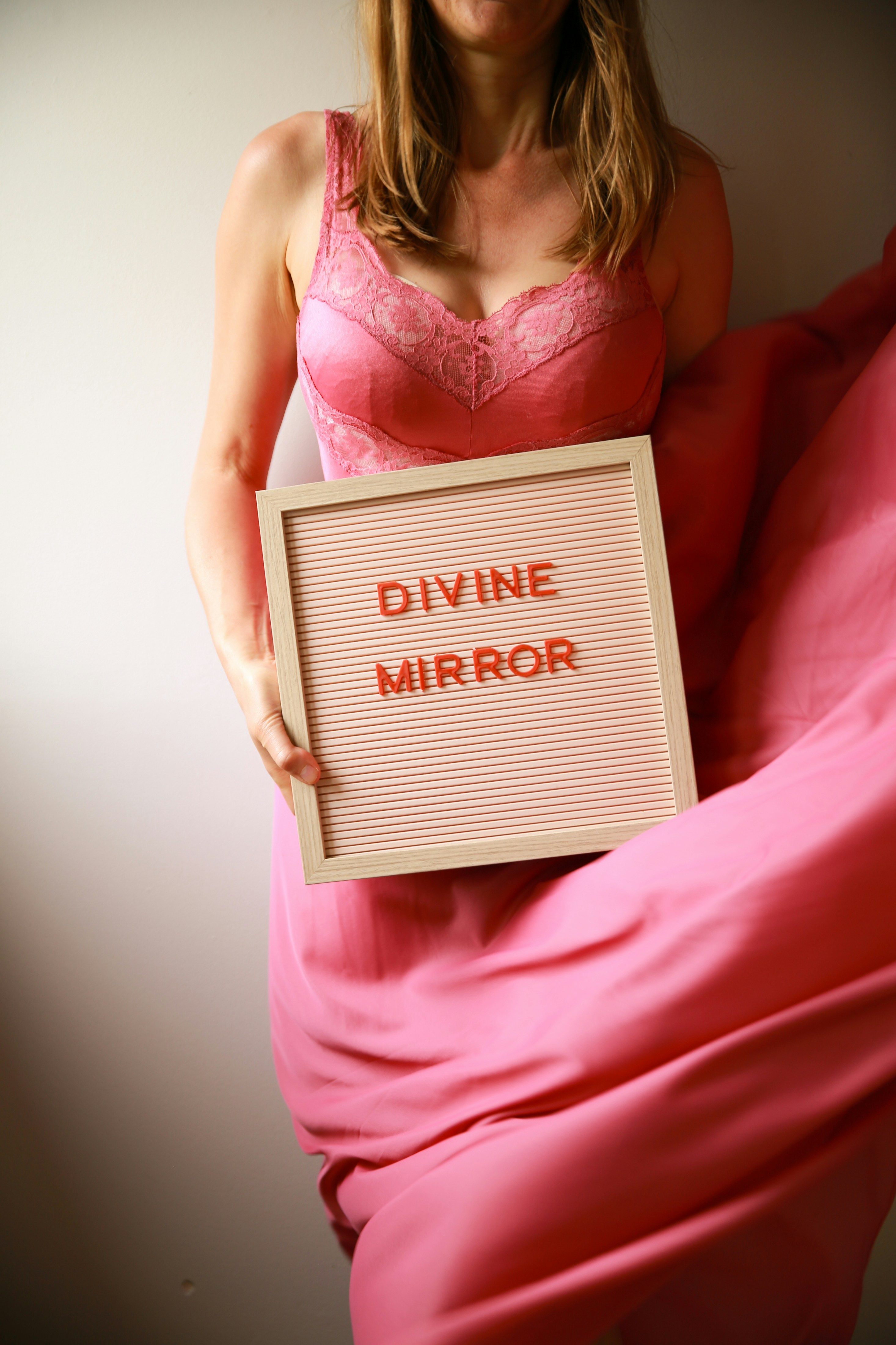 Die Frau hält ein Schild mit der Aufschrift "göttlicher Spiegel".