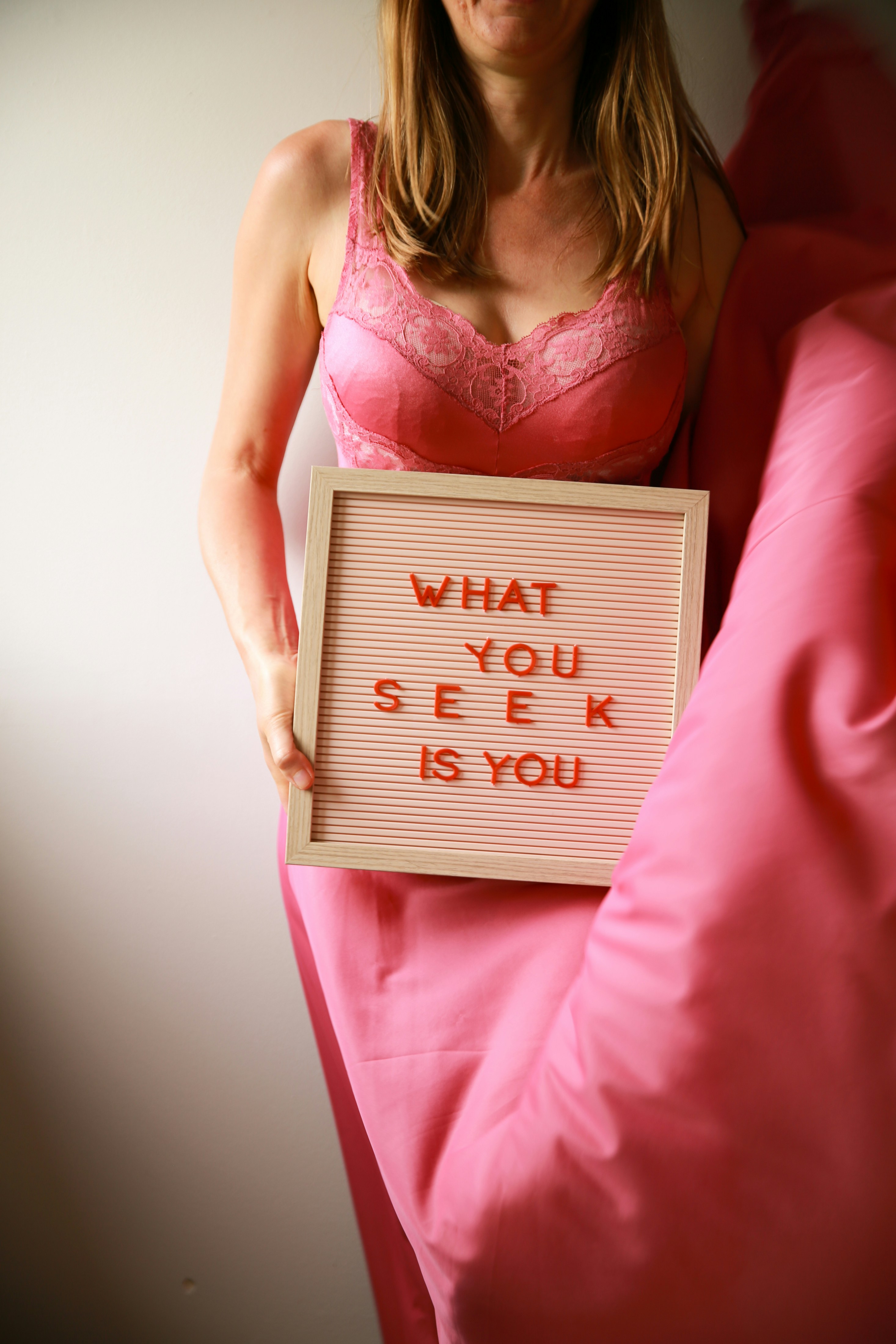Uma mulher segura uma placa que diz "o que você procura é você".