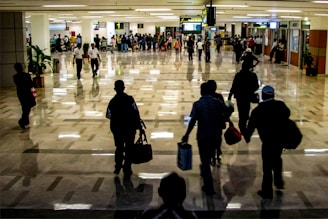 People are walking through a busy airport terminal.