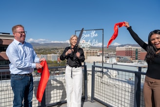 People are cutting a ribbon on a rooftop.