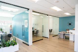 Modern office space with glass walls and light decor.