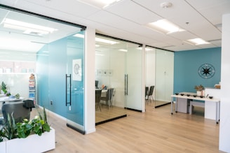 Modern office space with glass walls and light decor.