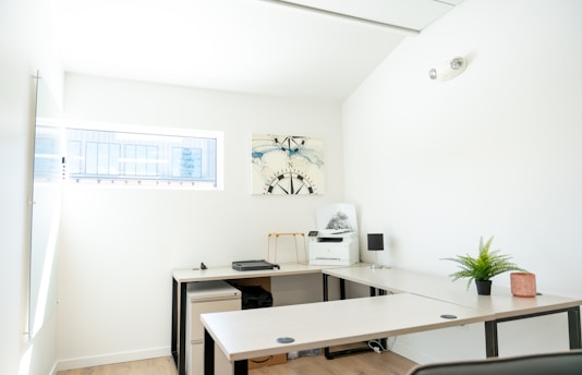 An empty, modern office with a desk and window.