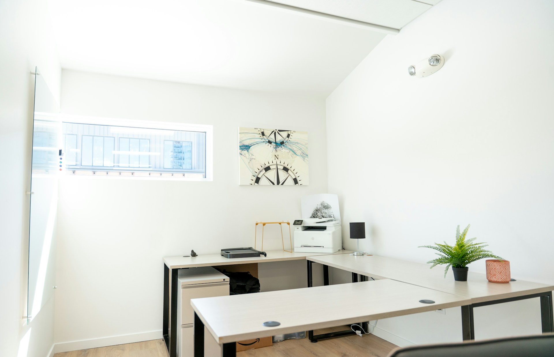 An empty, modern office with a desk and window.