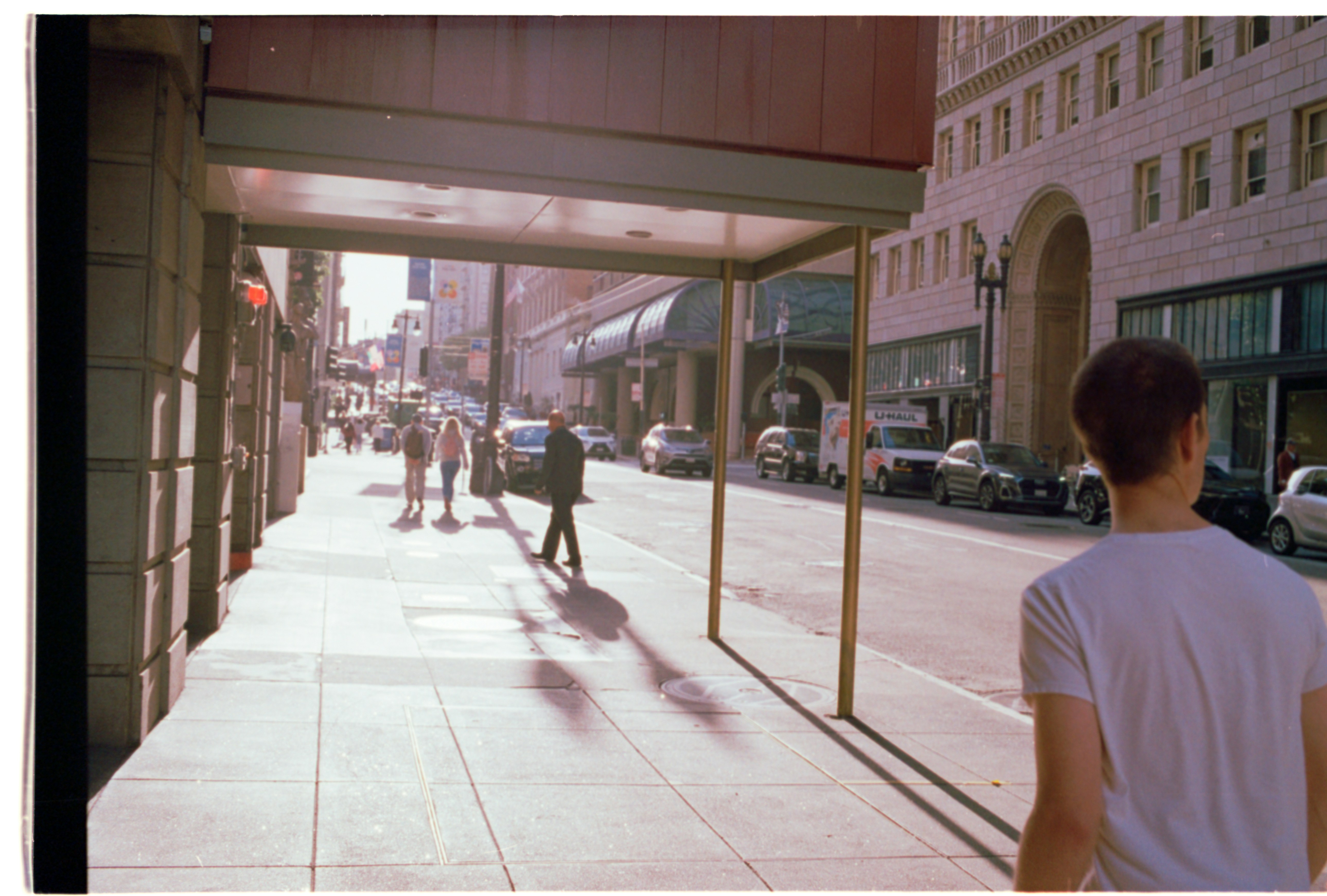 A person walks beside office buildings in late San Francisco light