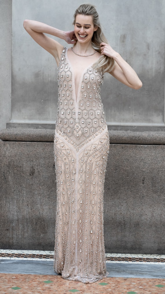 A woman poses in a beaded gown.