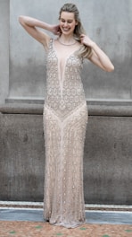 A woman poses in a beaded gown.