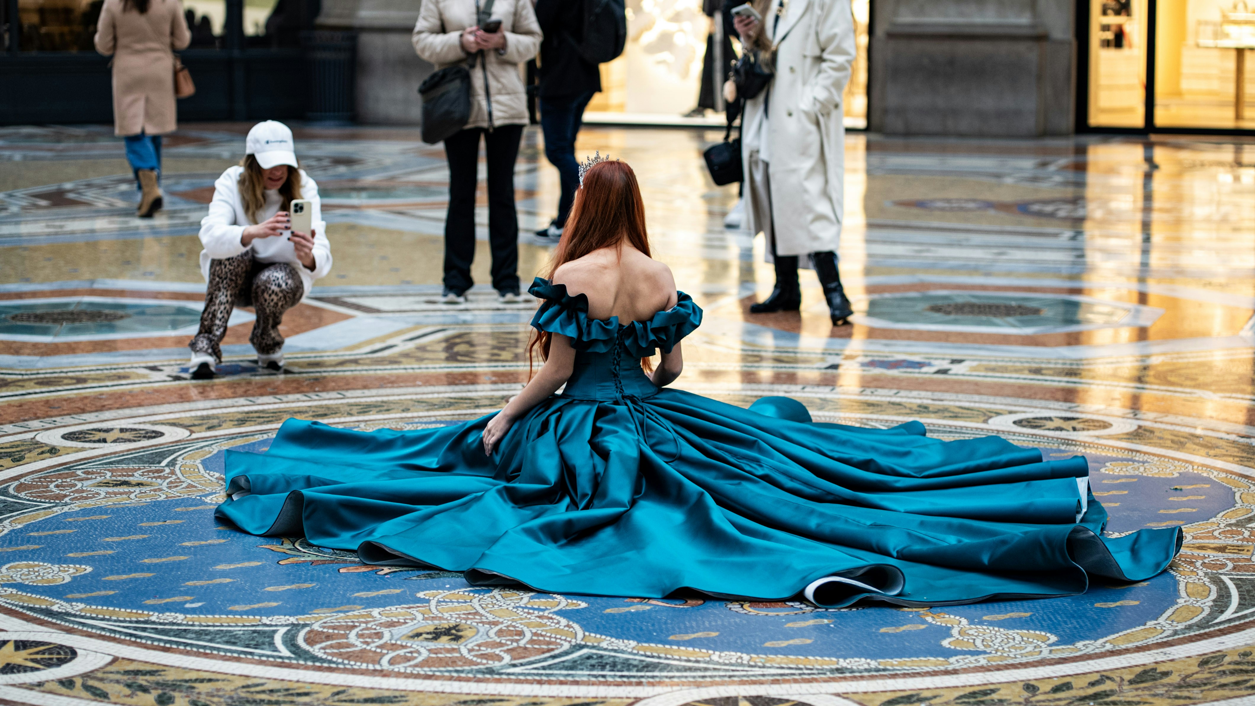 Woman in gown poses on a patterned floor