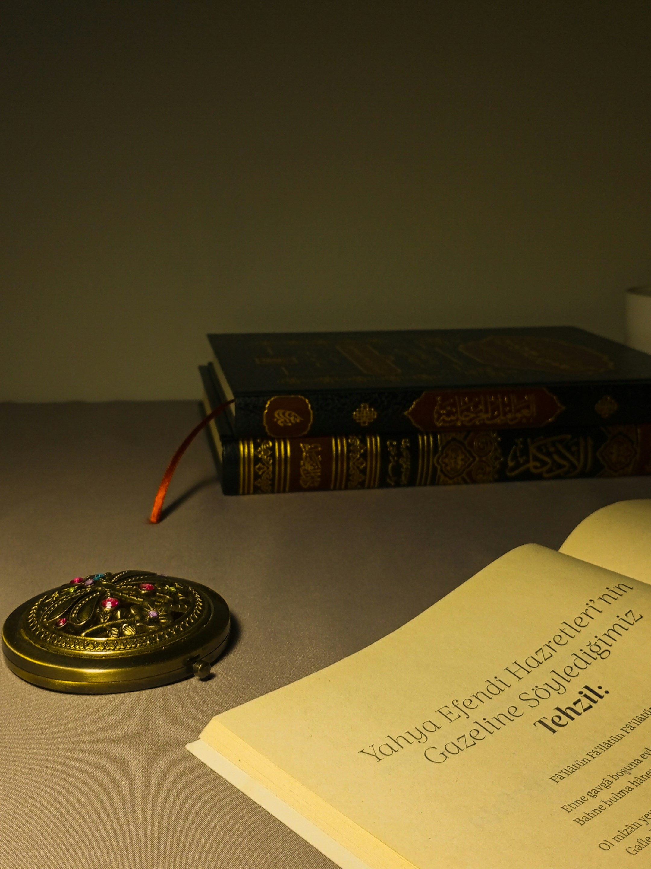 Books and a decorative container on a surface.