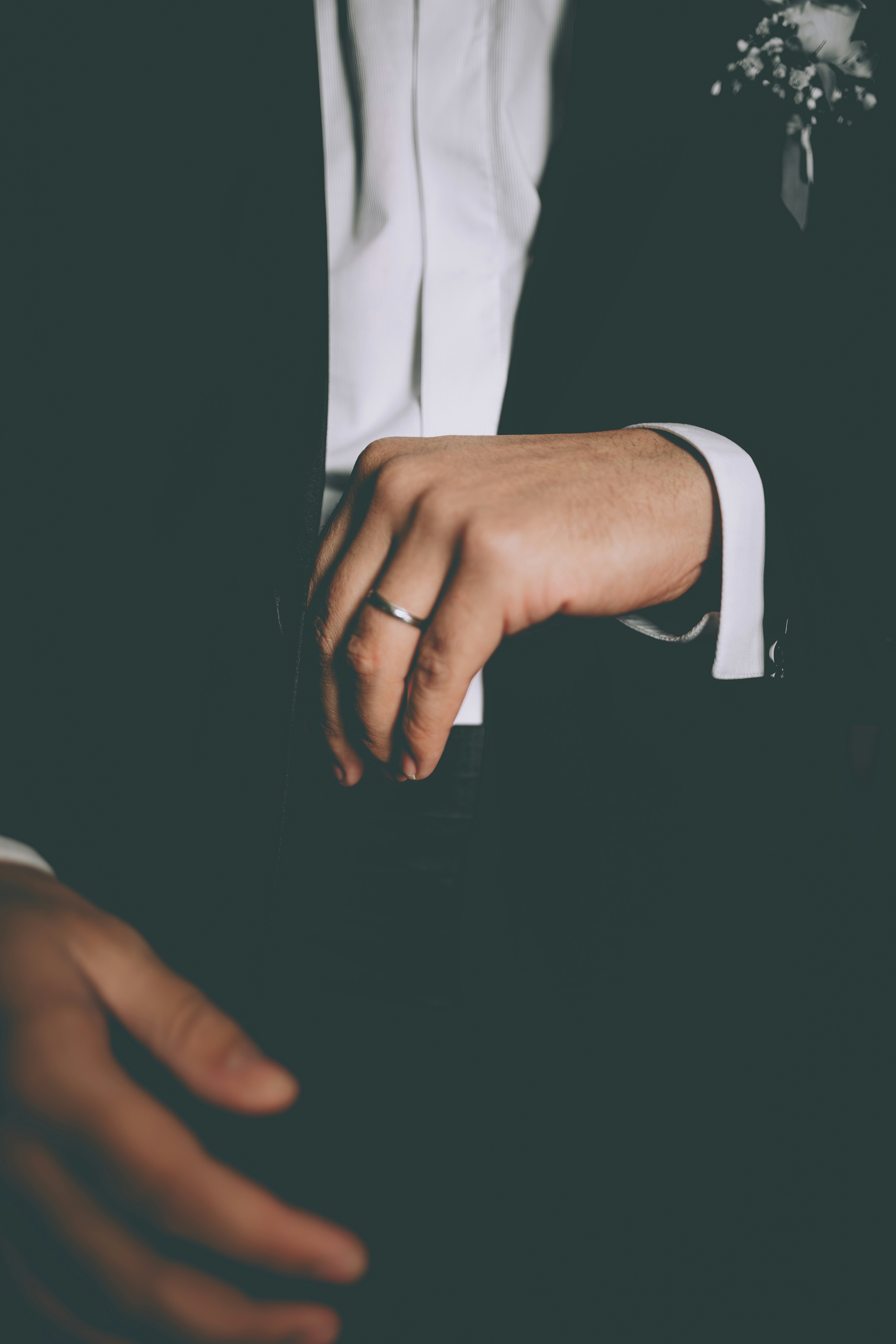 Un uomo che indossa un abito e una fede nuziale.