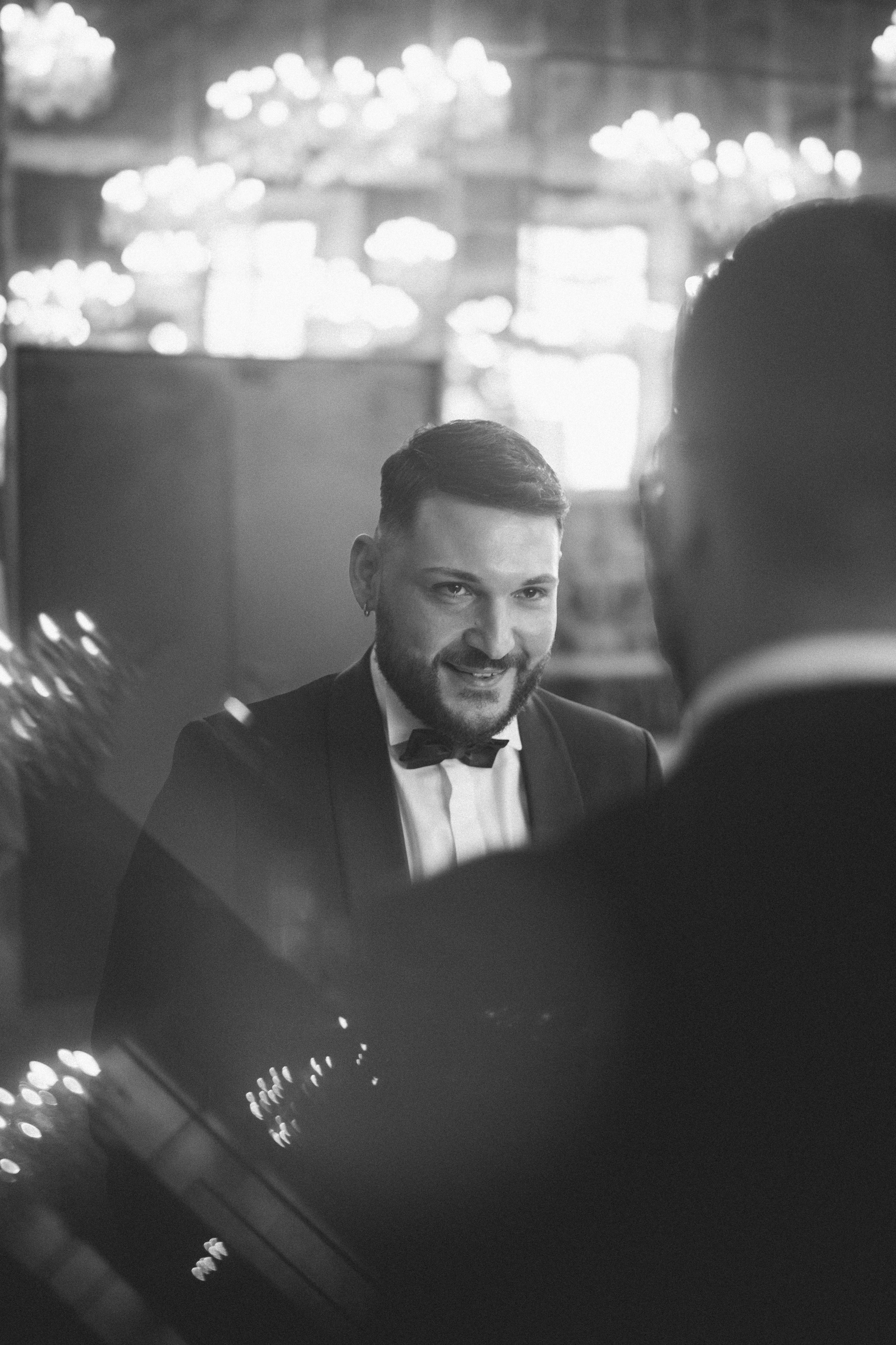 L'uomo in smoking sorride allo specchio.