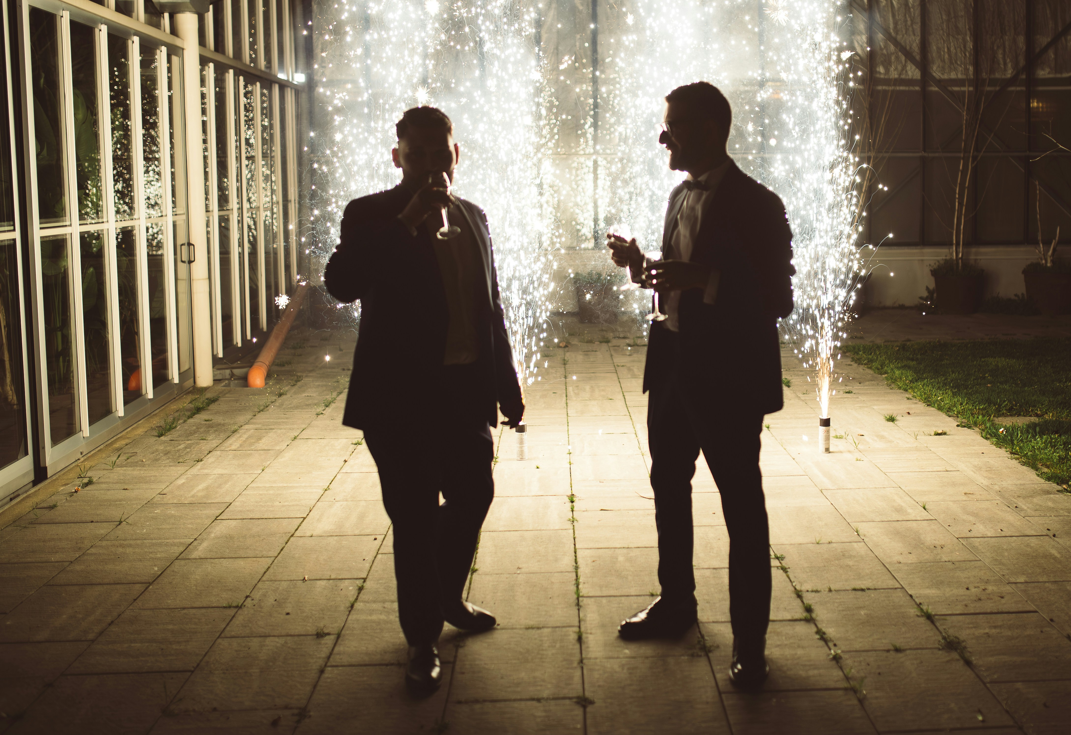 Due uomini festeggiano con stelle filanti di notte.