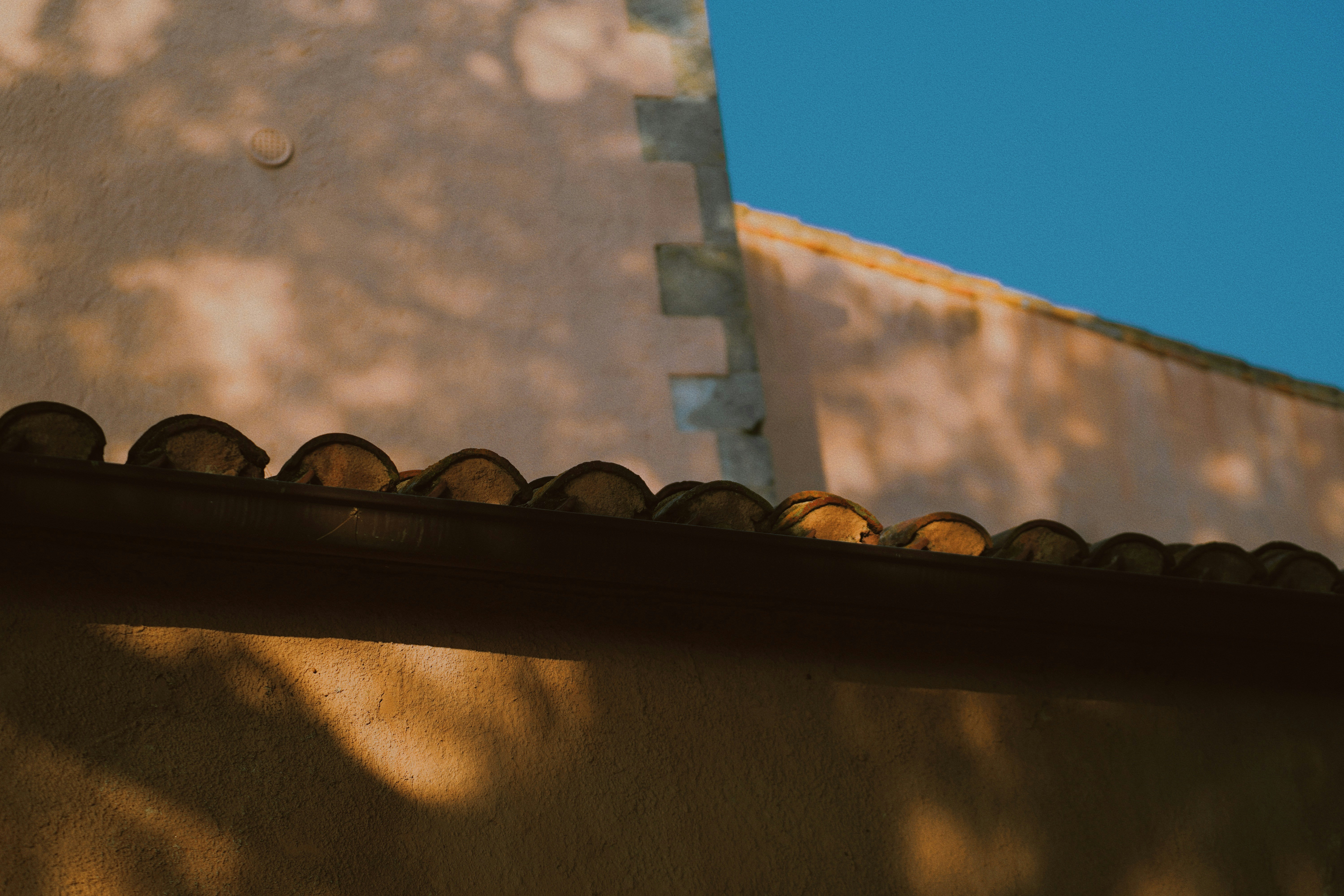 İspanya'da güneşli bir balkonda, arka planda geleneksel İspanyol mimarisi eşliğinde bütçe planlaması yapan huzurlu bir kişinin masası.