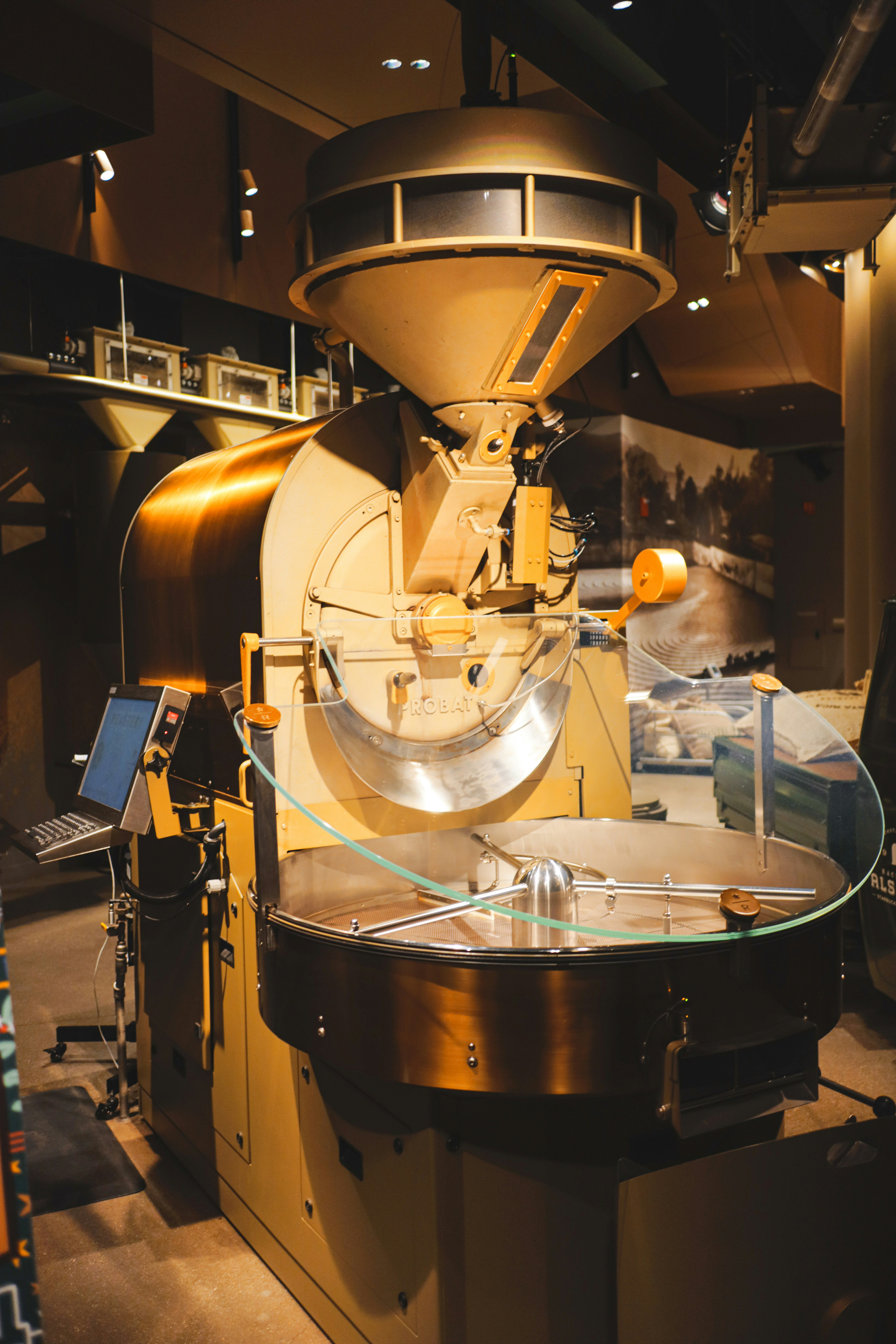A large coffee roaster is featured inside a cafe.