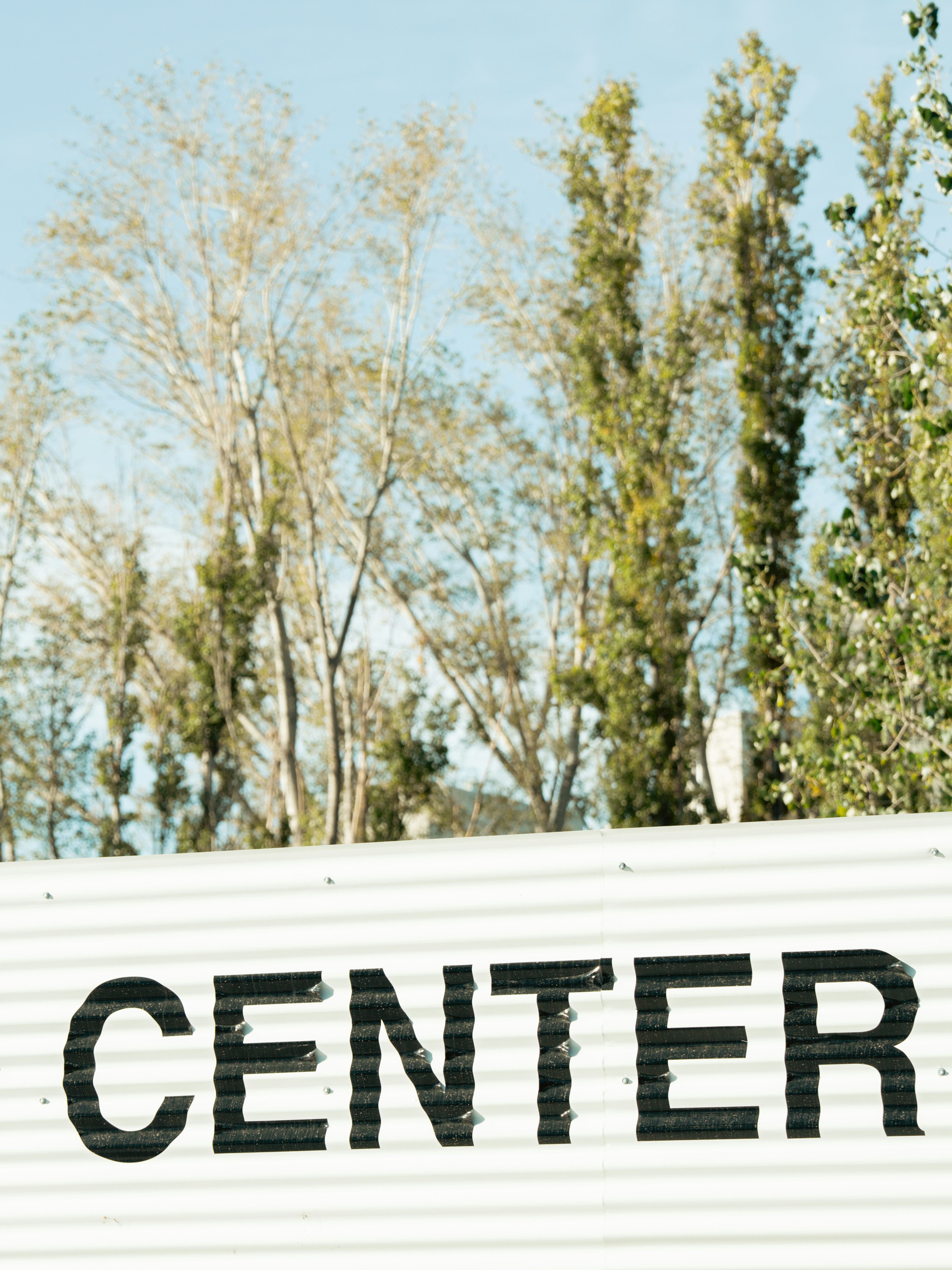 Trees are behind a building that says center