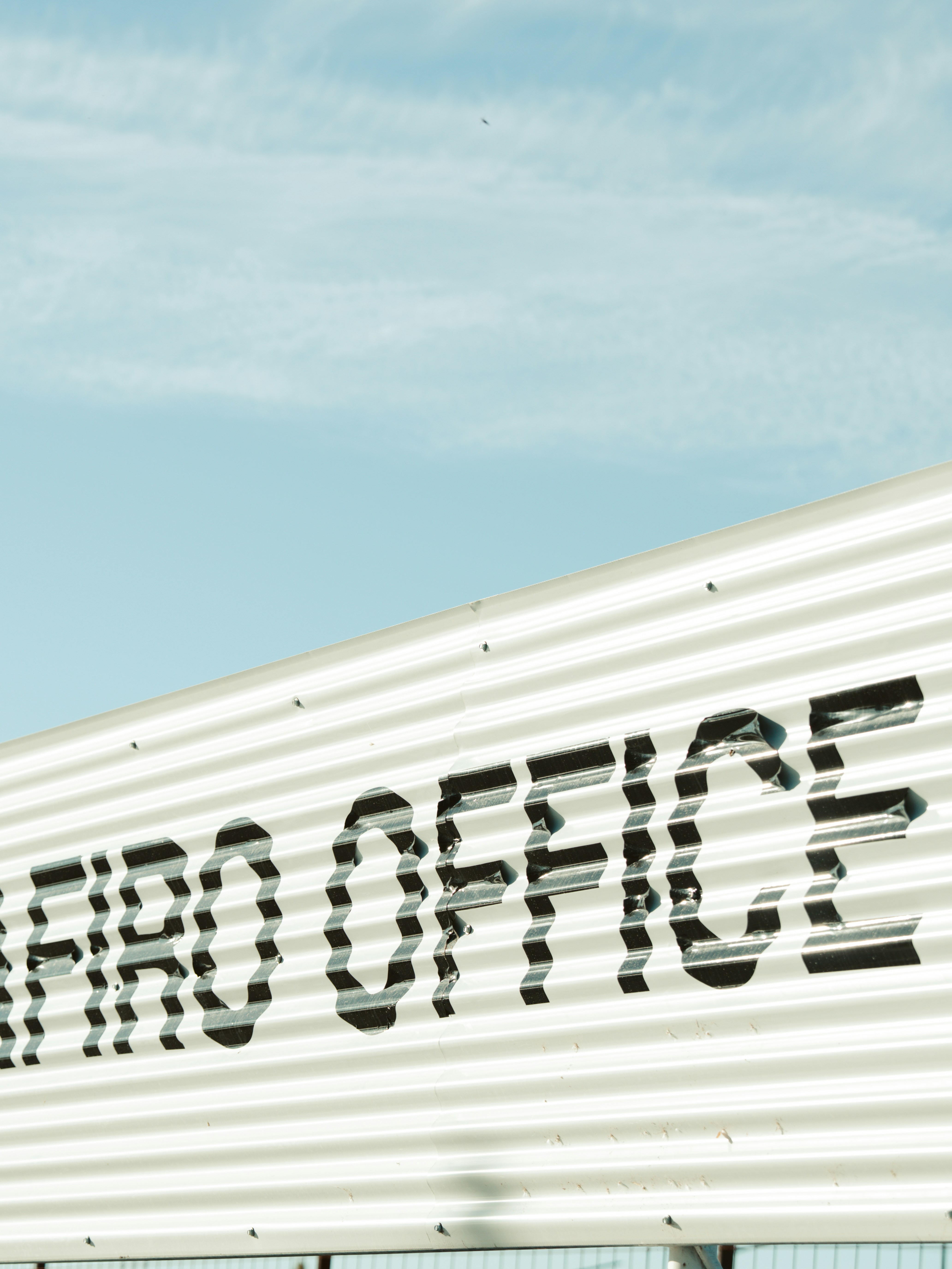 The sign reads "fair office" against a blue sky.