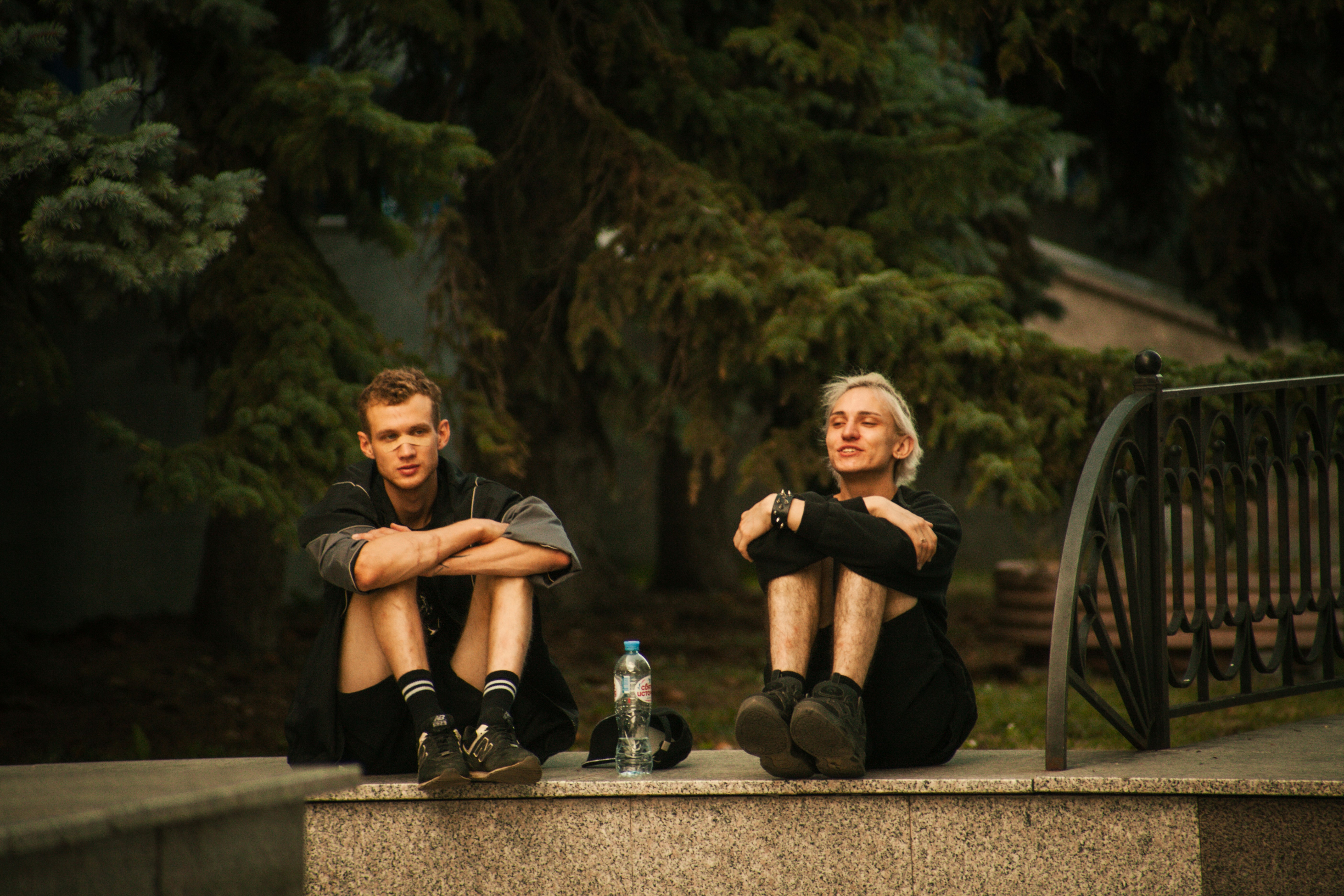 Two men sit outside, looking contemplative.