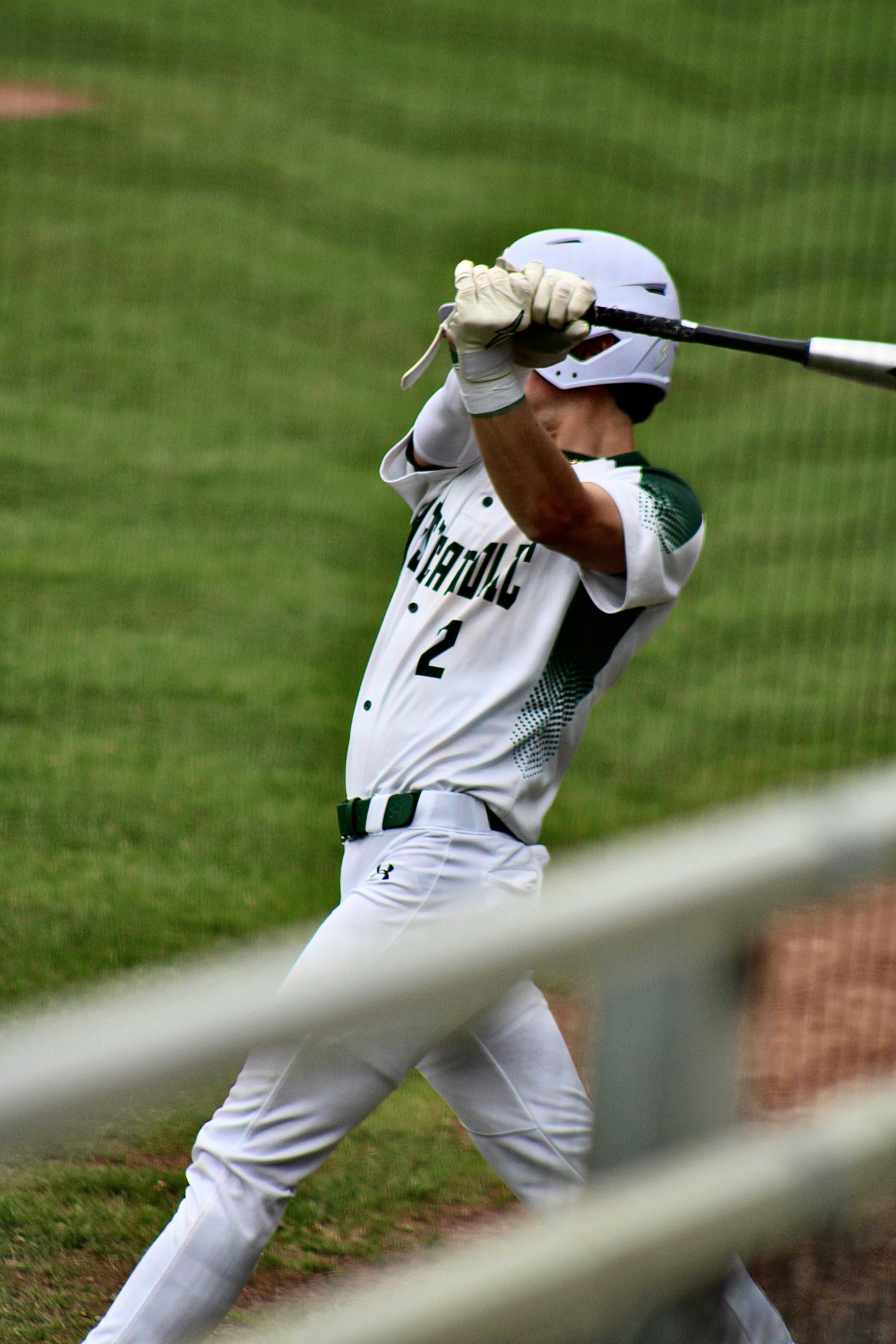 A baseball player swings his bat.