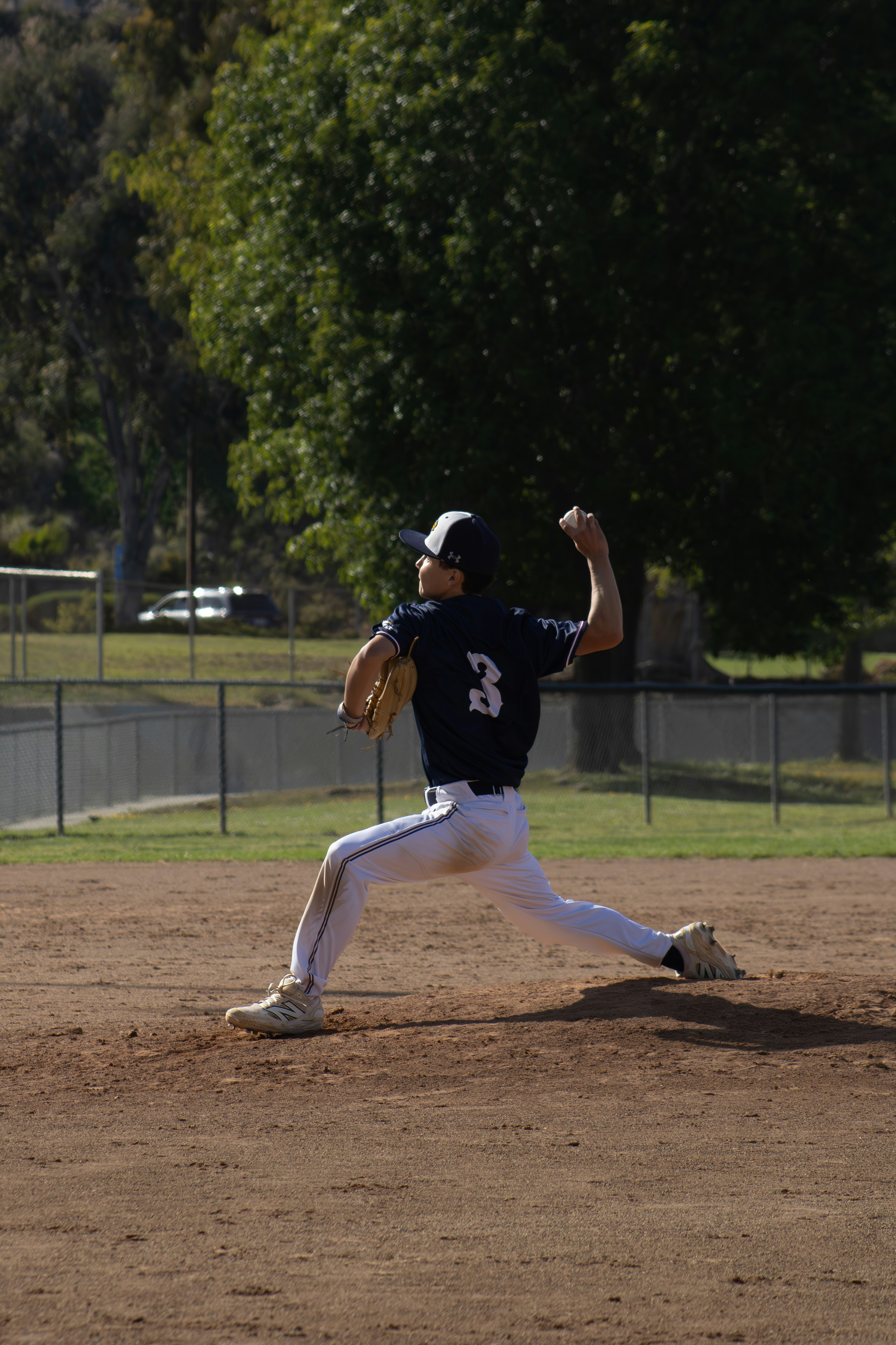 A baseball player pitches the ball in a game.