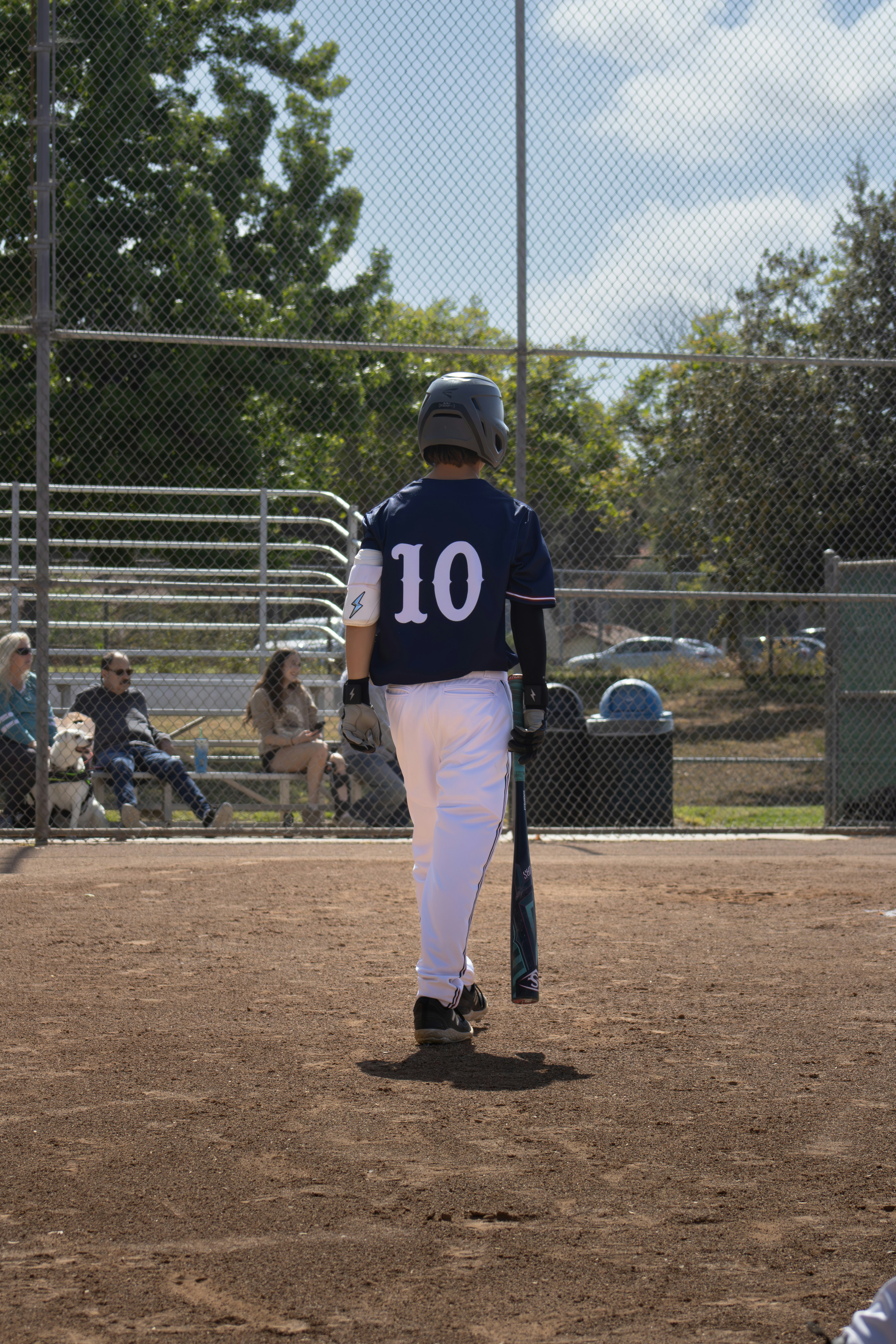 A baseball player walks away from the field.