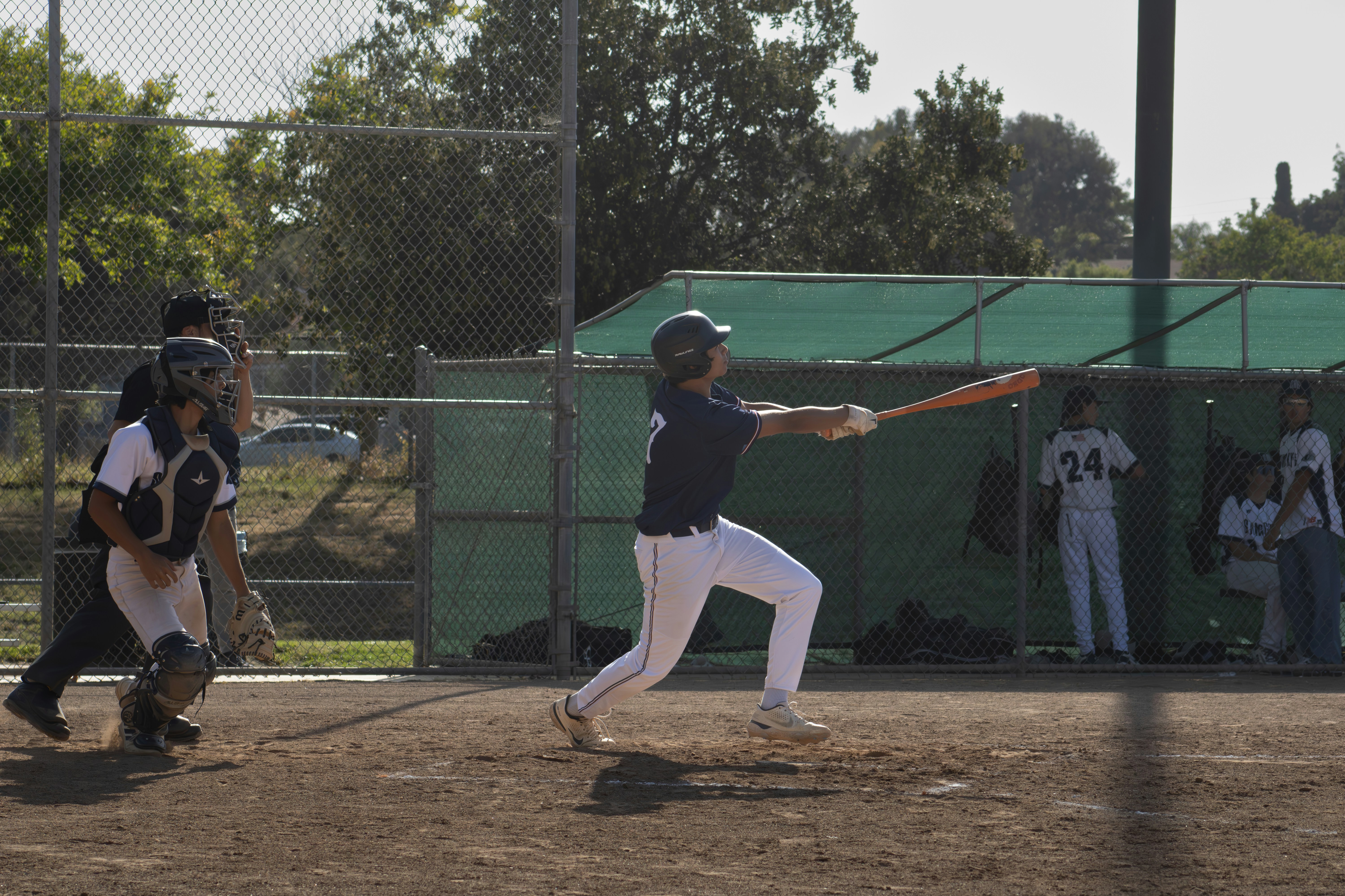 A baseball player swings at a pitch.