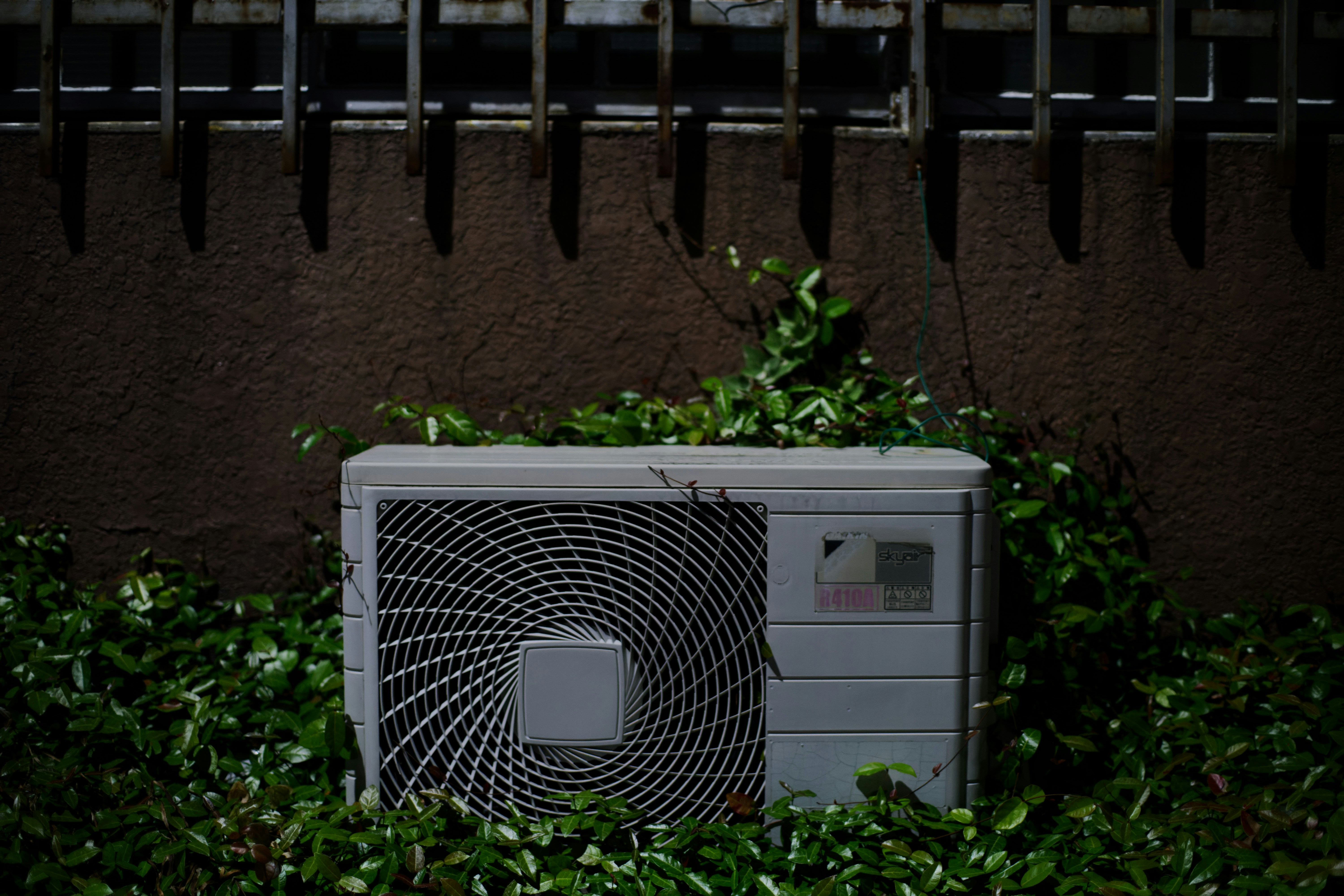 AC behind bushes