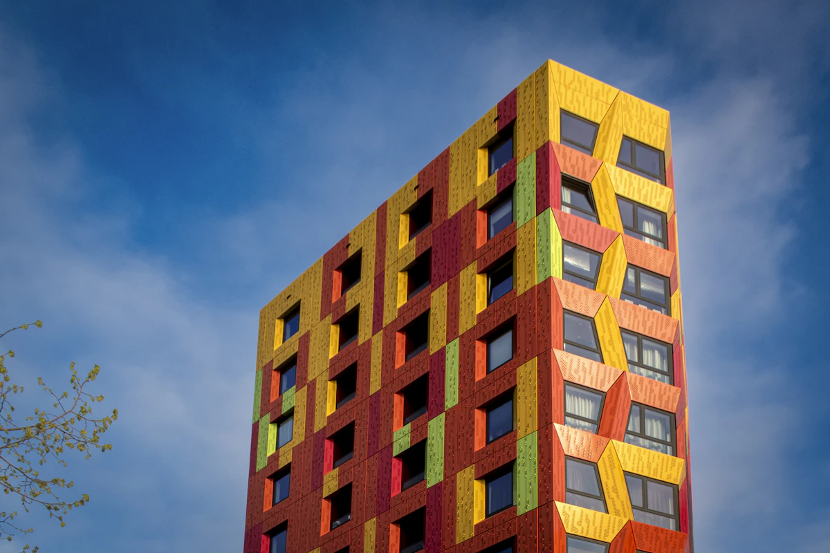 A red and yellow apartment building under a blue sky