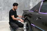 A man is working on a car's paint.
