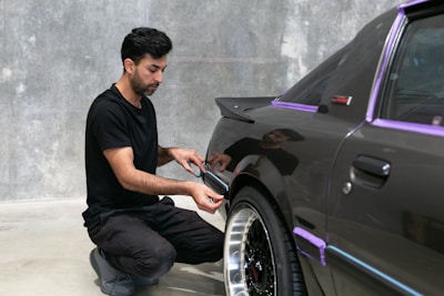 A man is working on a car's paint.