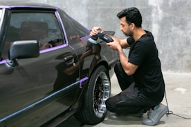 Man polishing a classic car's paintwork.