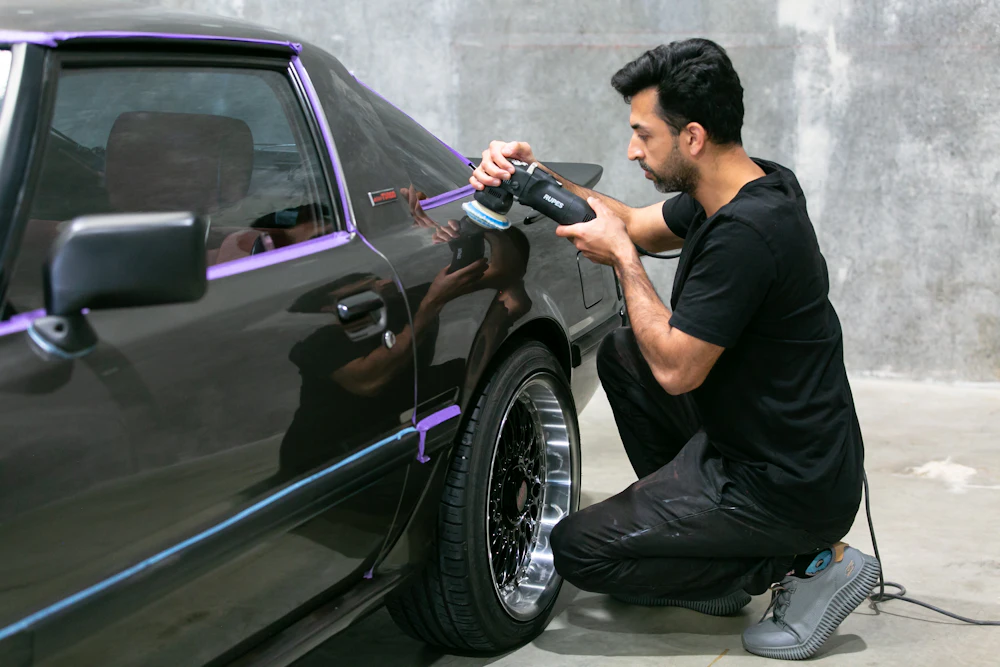 A detailer polishing a classic car