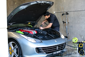 A mechanic is working on a ferrari car.