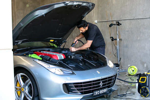 A mechanic is working on a ferrari car.