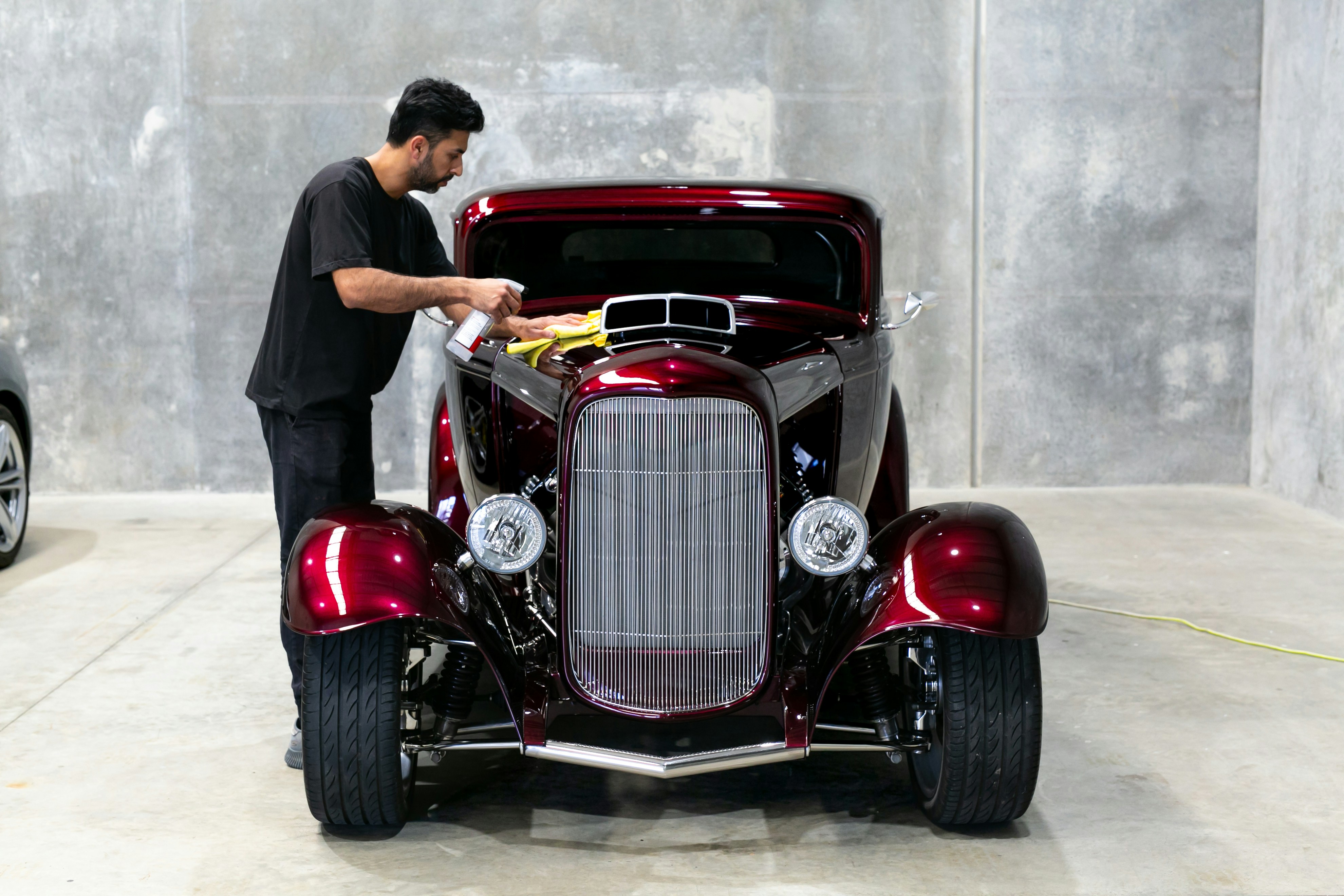 A man is working on a classic car.