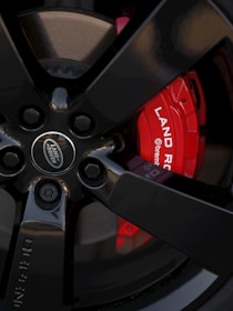 Land rover's wheel and red brake caliper are visible.