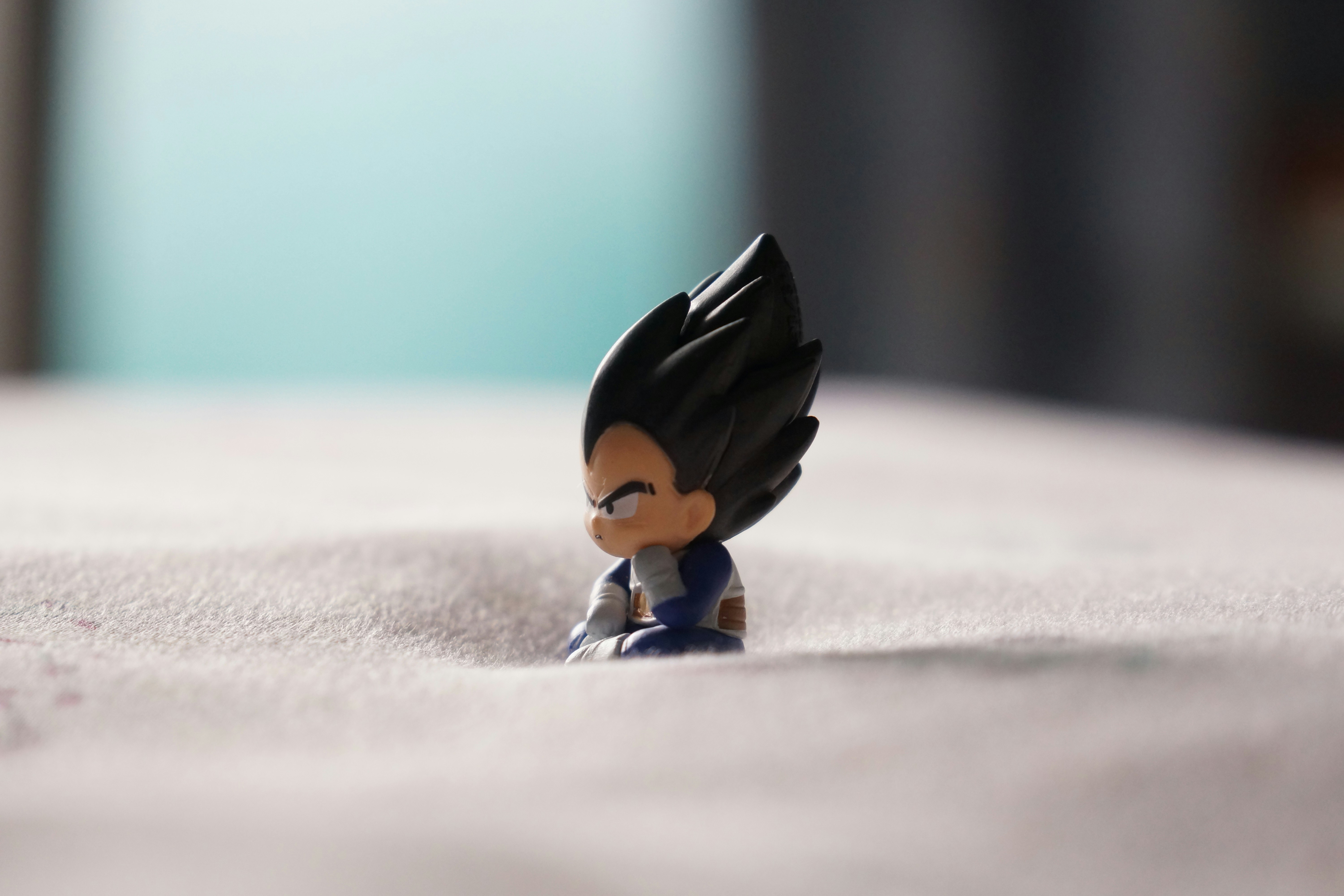 A small vegeta figurine sits on a surface.
