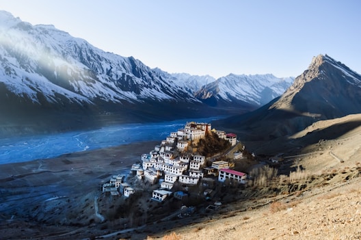 A mountain village nestled between majestic snowy peaks.