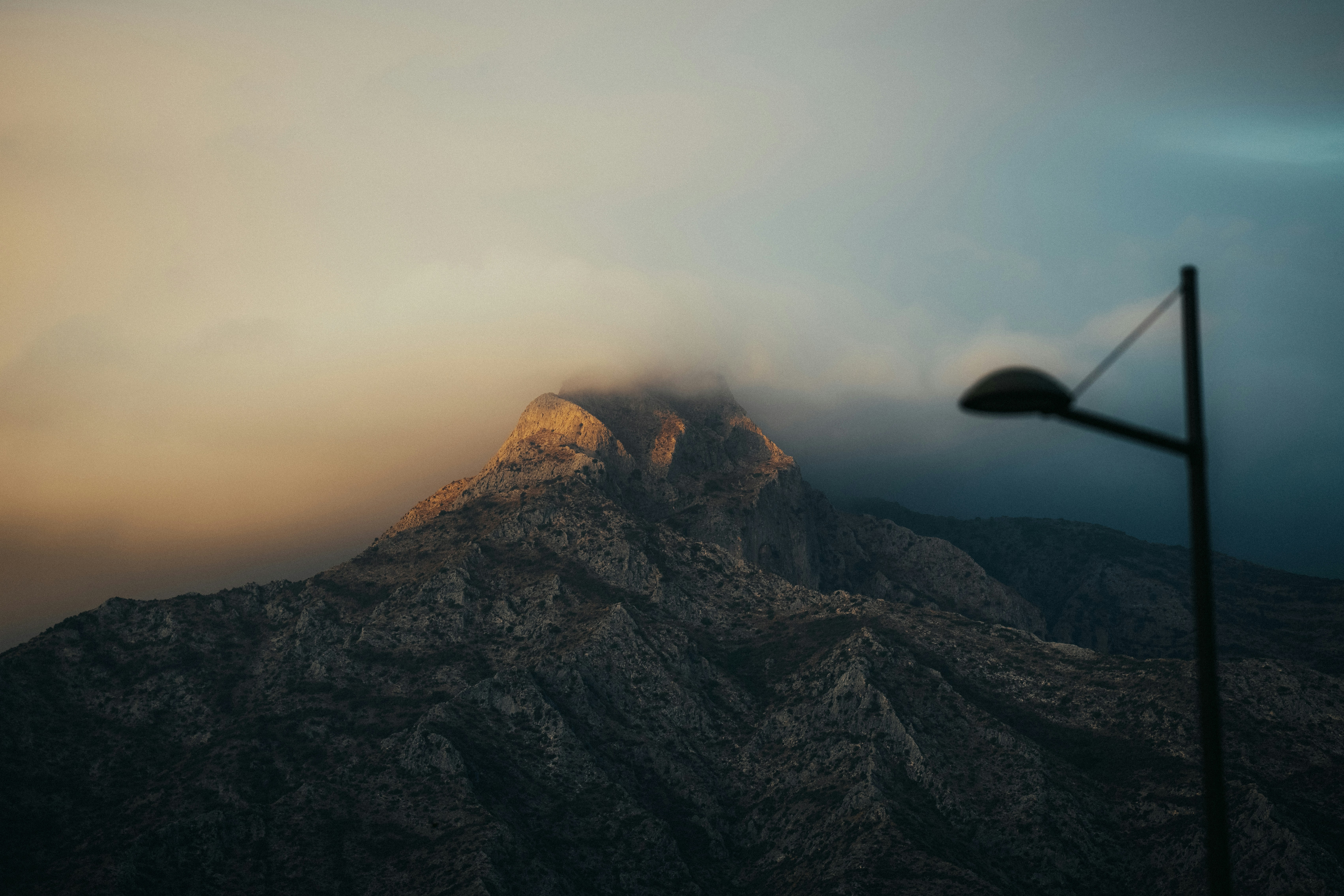 A mountain sits partially obscured by clouds.
