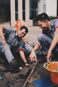 Workers are repairing a pipe on the ground.