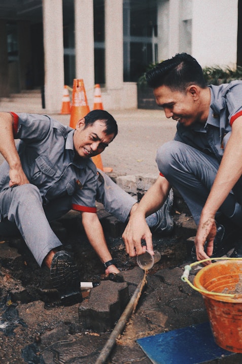 Workers are repairing a pipe on the ground.