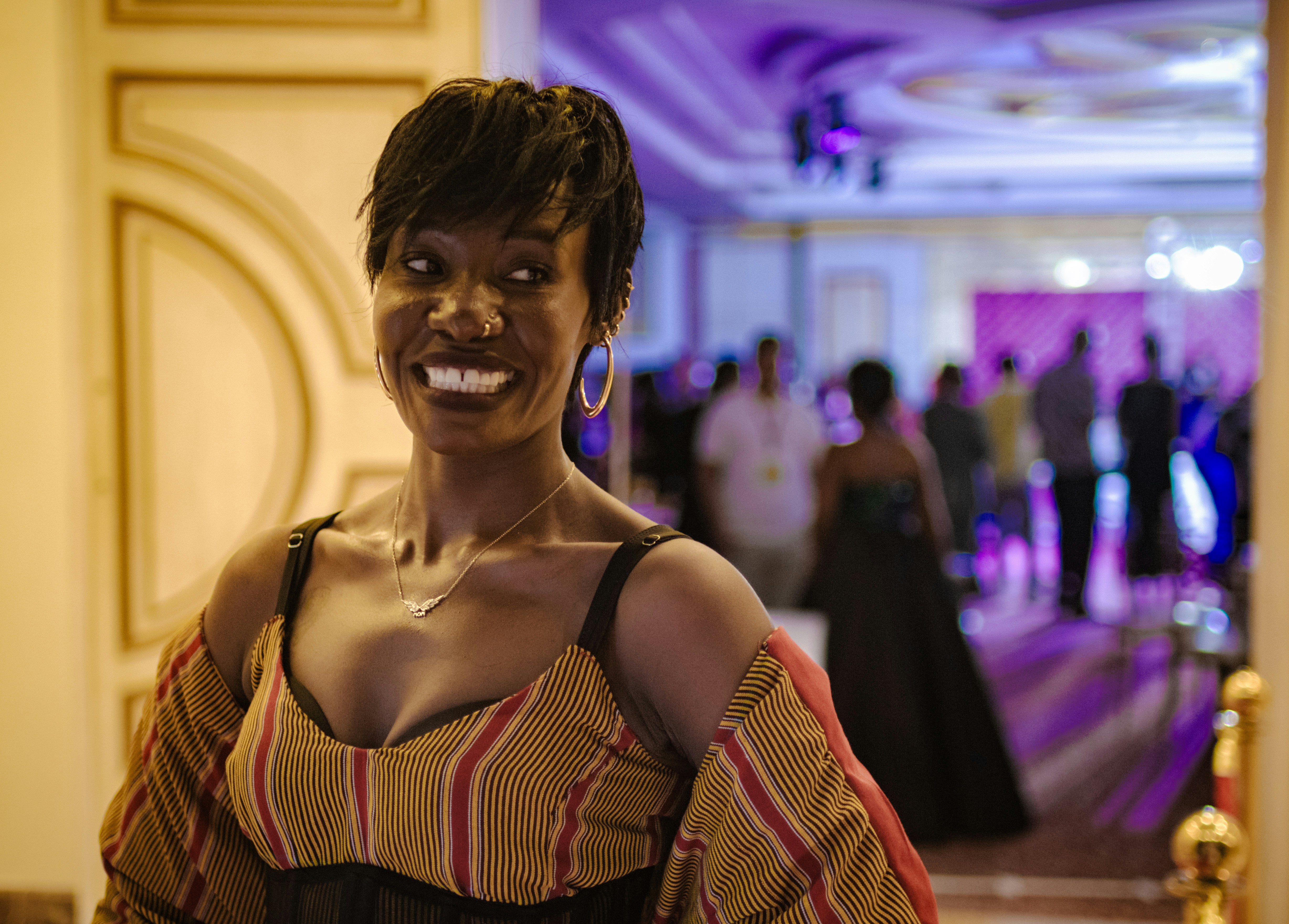 Woman smiles broadly, posing at a social event