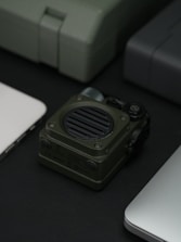 A green speaker is centered with several gadgets.