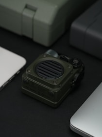 A green speaker is centered with several gadgets.