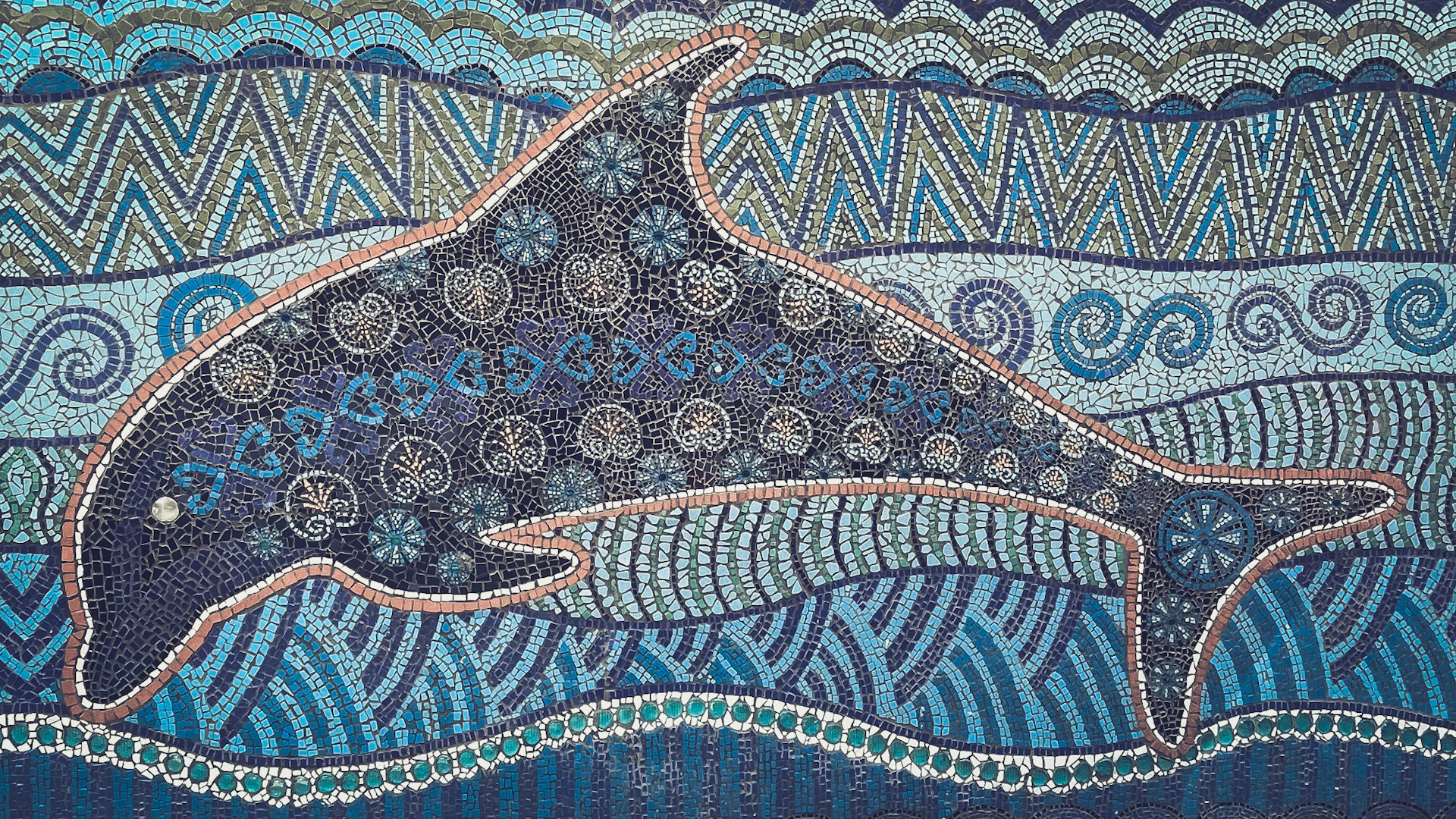 A detailed, blue dolphin is swimming in the ocean.