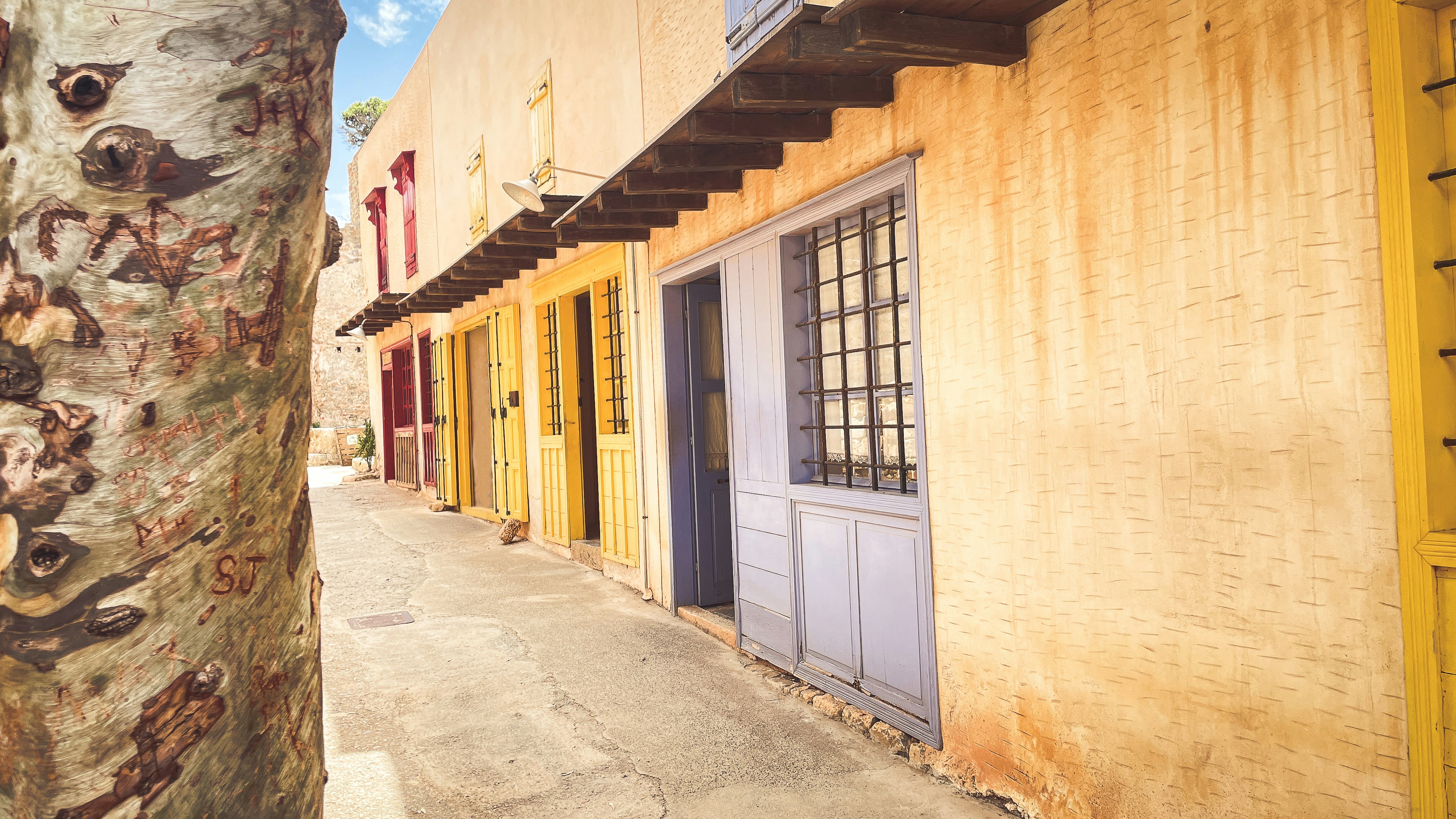 Bunte Gebäude säumen eine schmale Gasse.