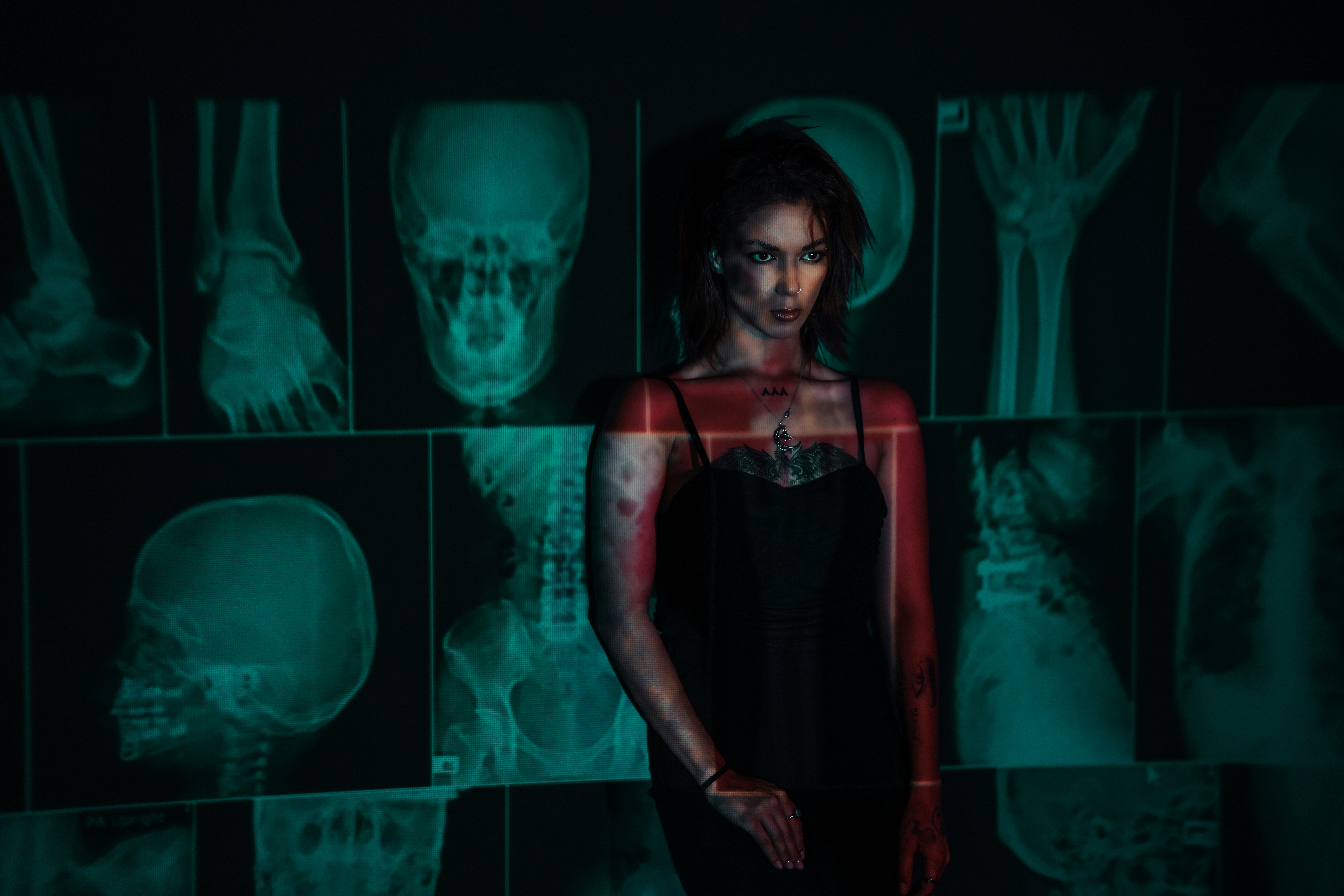 A woman stands against x-rays, looking at the camera.