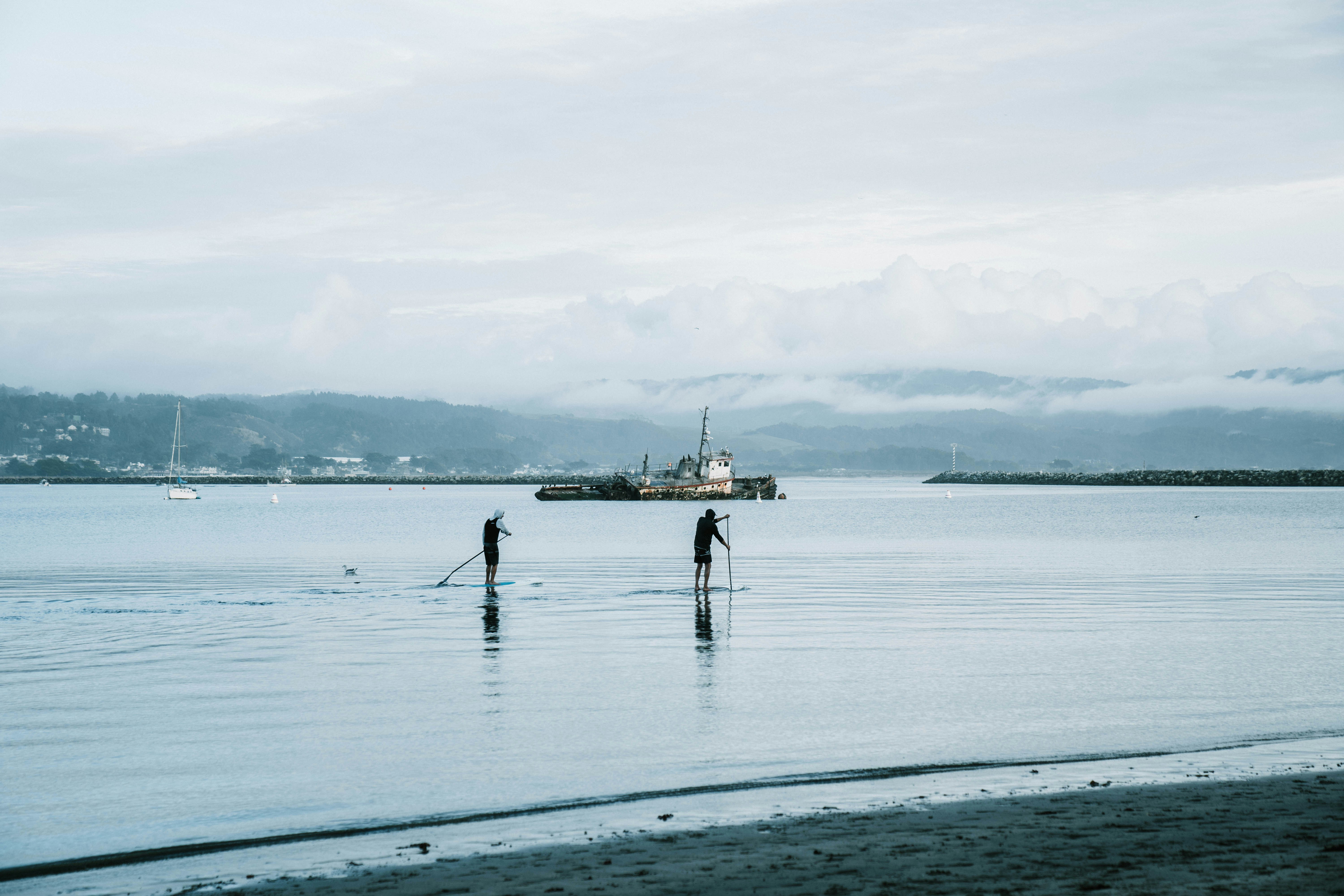 Two people paddleboarding on calm water.